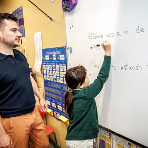 Photo of a teacher working at a whiteboard.